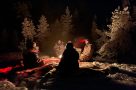 Hot chocolate around the fire on a Northern Lights sled tour